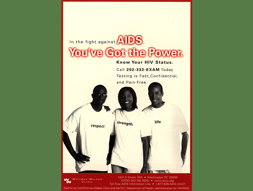 African American woman between two African American men, all smiling and looking at the viewer. Each is wearing a shirt with a different word on it