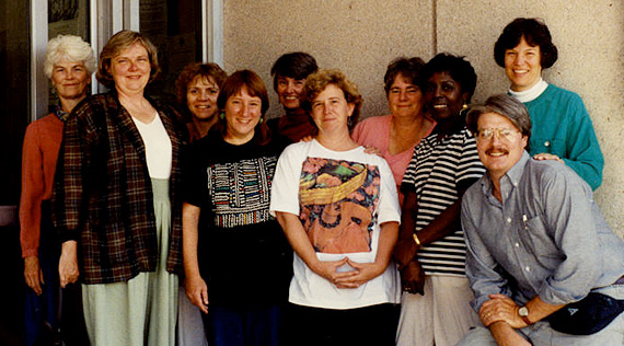 Nine women and one man stand for a photograph in front of a hospital entrance.