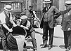 Black and white photograph of police officers overseeing the pouring out of alcohol.