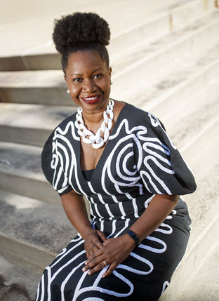 Photograph of a Black woman outdoors.