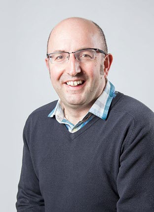 Informal photograph of a white man in a sweater.