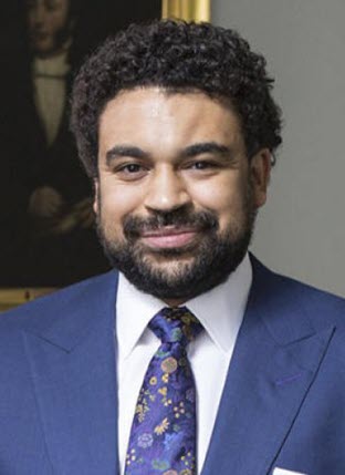 Informal photograph of a Black man in a suit.