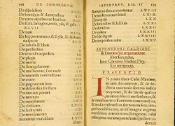 Book opened showing Latin text with manuscript initial letter 'I' in red ink